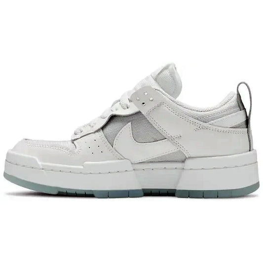 Nike Dunk Low Disrupt Wmns Photon Dust – Seitenansicht des weißen Nike Damen-Sneakers mit grauen Overlays, Mesh-Einsätzen und heller Plateausohle auf weißem Hintergrund