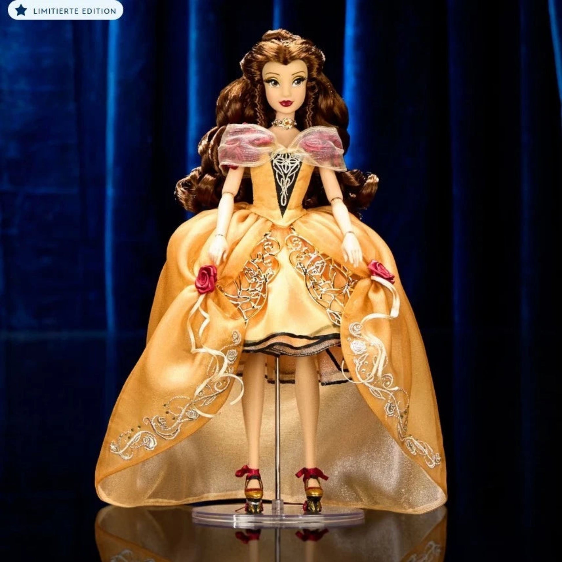 Disney Designer Collection Belle Puppe aus Die Schöne und das Biest – limitierte Sammleredition in goldenem Kleid mit Rosenverzierung, Vorderansicht auf dunklem Bühnenhintergrund