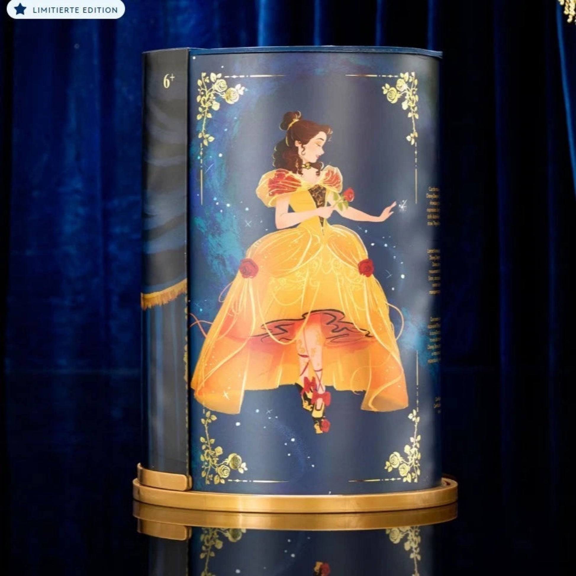 Disney Designer Collection Belle Puppe in Sammlerbox – limitierte Edition aus Die Schöne und das Biest mit goldener Verpackung und Illustration, Seitenansicht der Präsentationsbox vor blauem Hintergrund