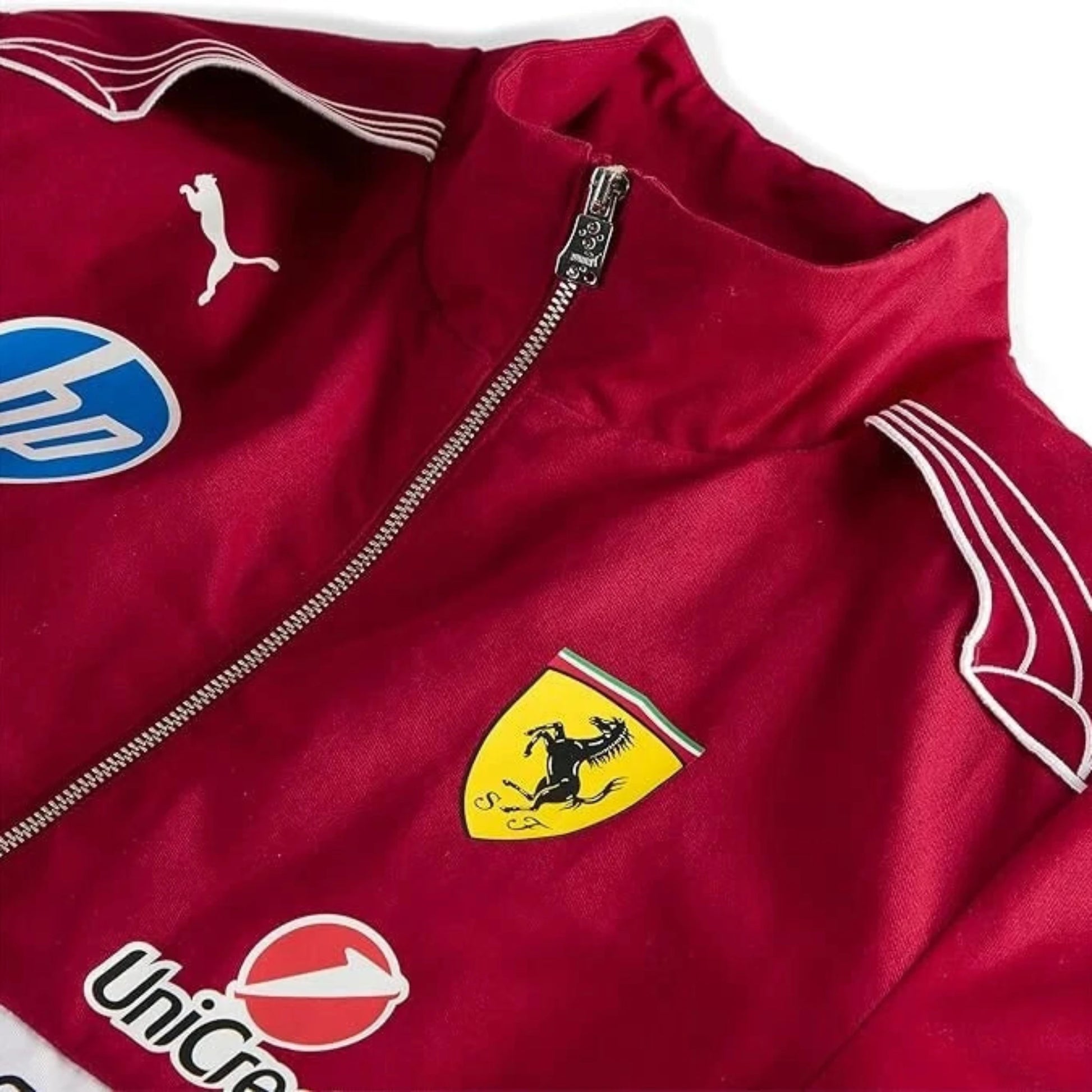 Detailaufnahme der PUMA Scuderia Ferrari Retrojacke in Rot mit Ferrari-Logo und Sponsorenaufnähern – hochwertige Motorsportjacke im Vintage-Design.