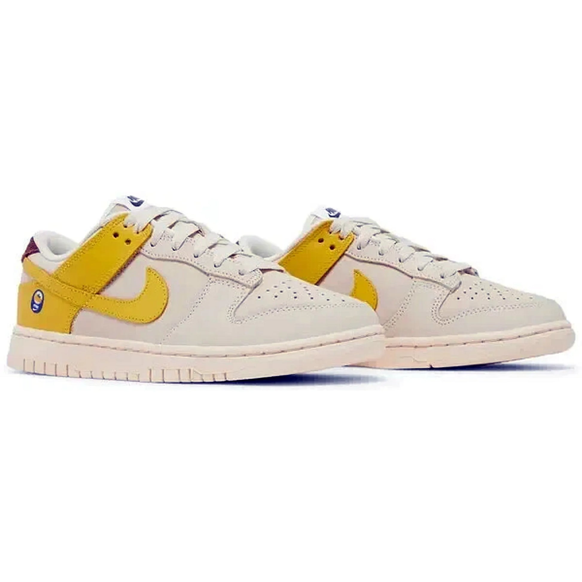 Nike Dunk Low LX Wmns Banana – Paaransicht des beigen und gelben Damen-Sneakers mit Bananen-Detail auf der Ferse, weißer Zwischensohle und hellem Hintergrund
