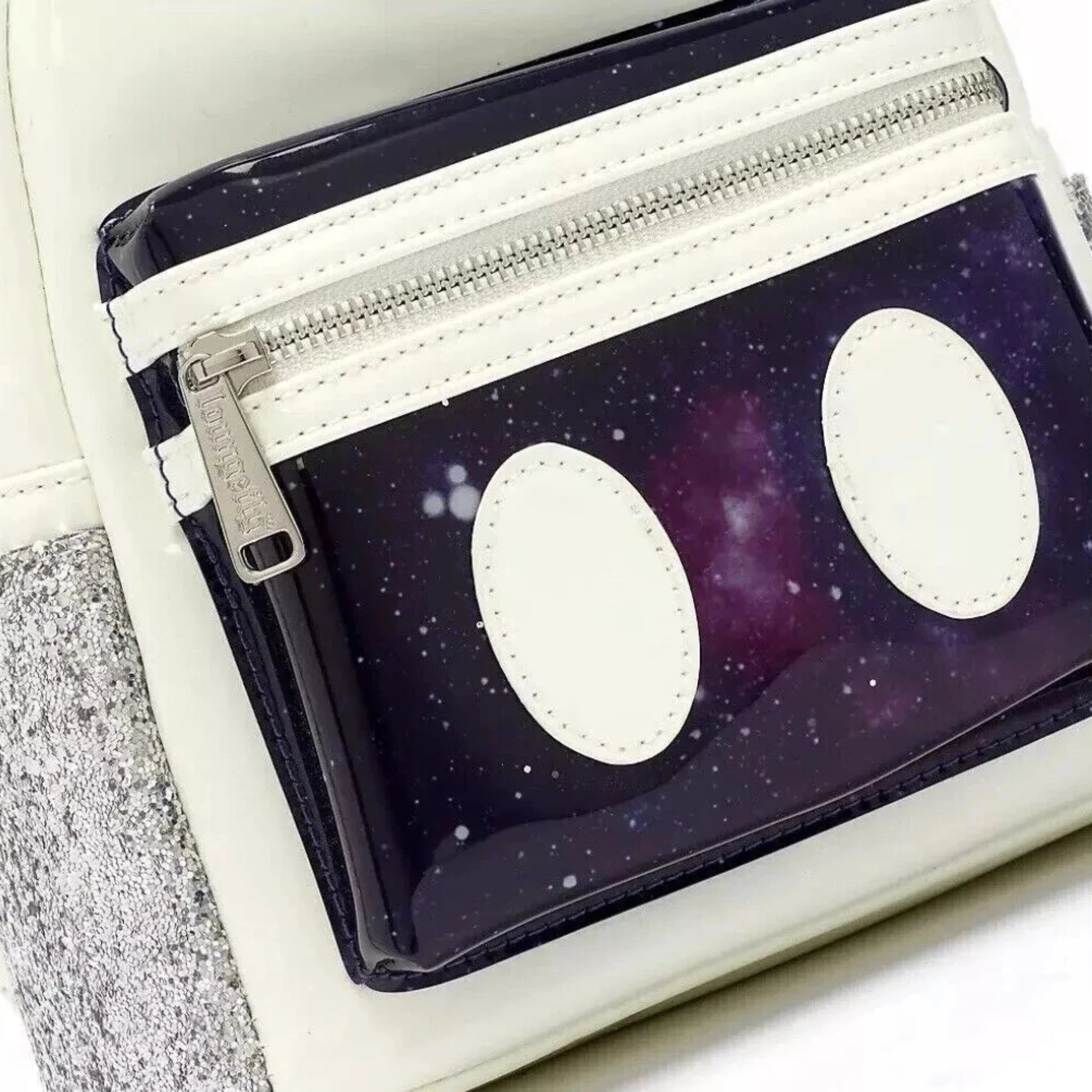 Detailaufnahme des Loungefly Micky Maus Mini-Rucksacks – galaktisches Frontfach mit zwei weißen Applikationen im Micky-Stil und silbernem Reißverschluss.