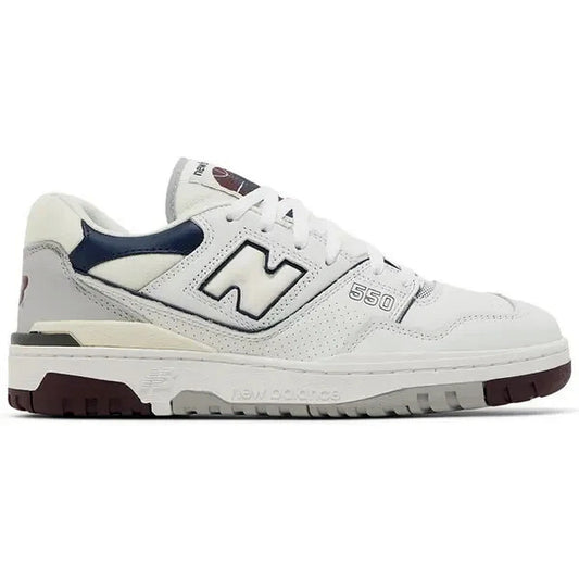 New Balance 550 White Natural Indigo Burgundy – Seitenansicht des weißen Retro-Sneakers mit navyblauen und bordeauxfarbenen Akzenten, perforiertem Leder und ikonischem „N“-Logo für einen sportlich-eleganten Look.