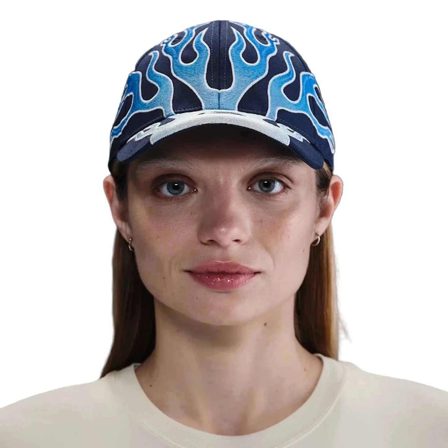 Nike Club Cap in Navyblau mit hellblauen Flammenstickereien – frontal getragene Streetwear-Kappe im Retro-Stil, kombiniert mit einem cremefarbenen Nike Sweatshirt.