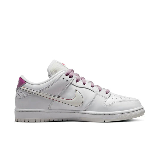 Nike SB Dunk Low Pro Be True – Seitenansicht des weißen Low-Top-Sneakers mit pastellfarbenem Swoosh, violetten Schnürsenkeln und Regenbogen-Details auf weißem Hintergrund.