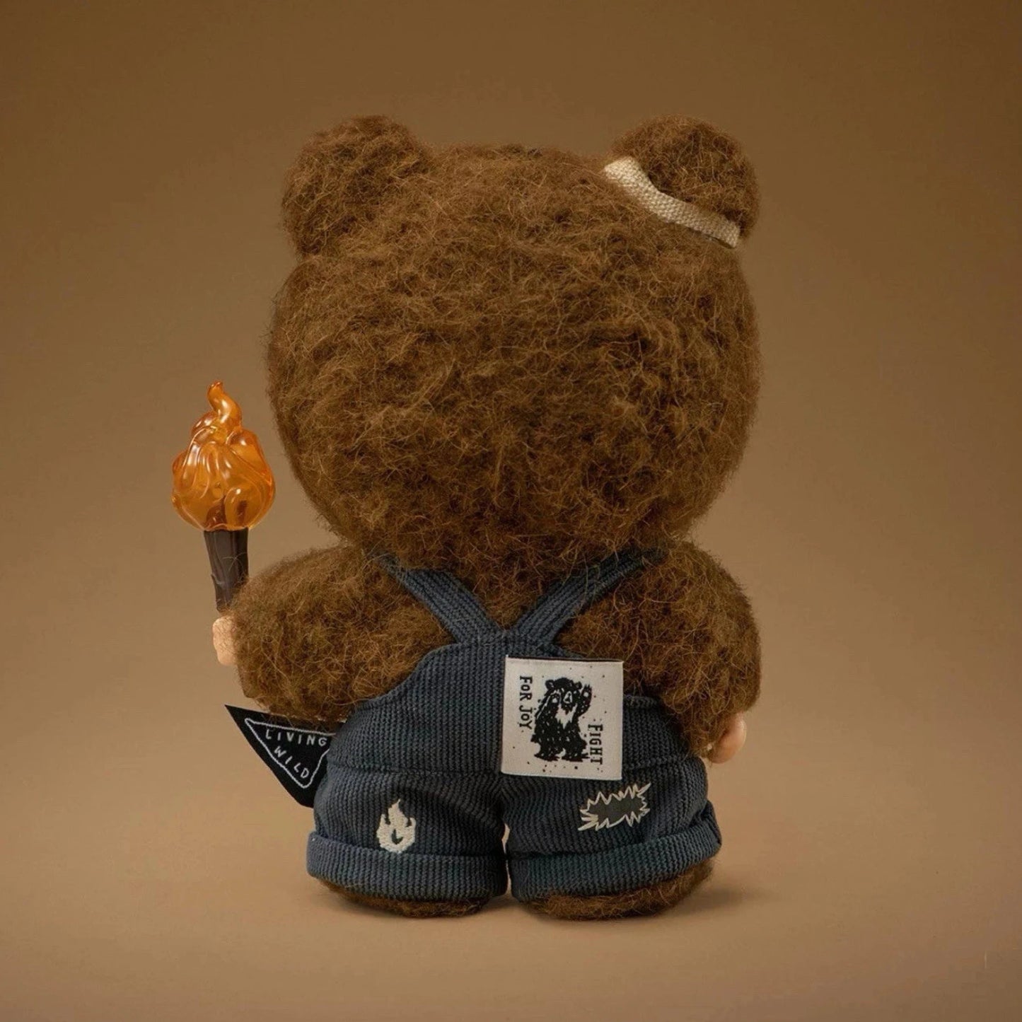 POP MART Hirono Figur Rückansicht – Designerfigur aus der Living Wild Serie, zeigt die detailreiche Rückseite des Bärenkostüms mit Fackel und Stoff-Overalls.