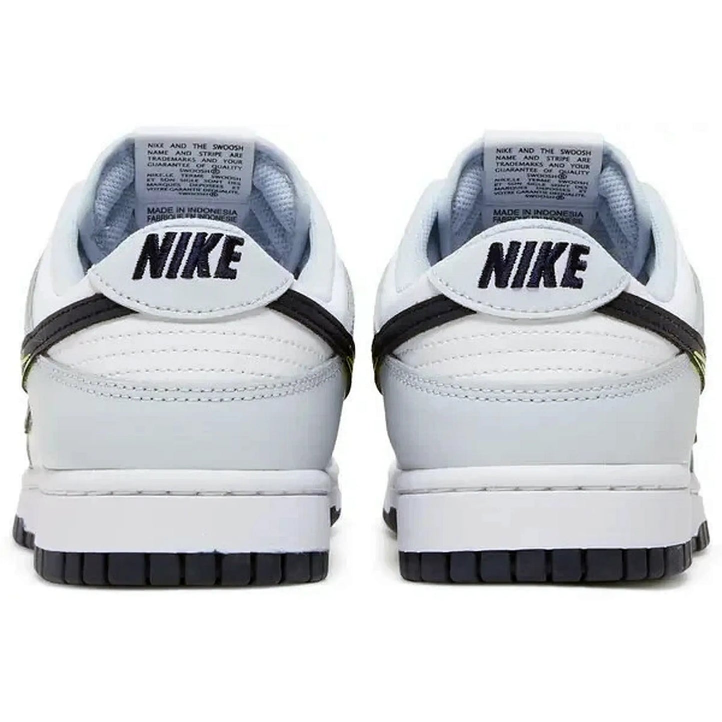 Nike Dunk Low 3D Swoosh – Rückansicht der weißen Sneaker mit schwarzem „NIKE“-Schriftzug auf der Ferse, mehrfarbigem 3D-Swoosh an der Seite und dunkelgrauer Außensohle auf weißem Hintergrund