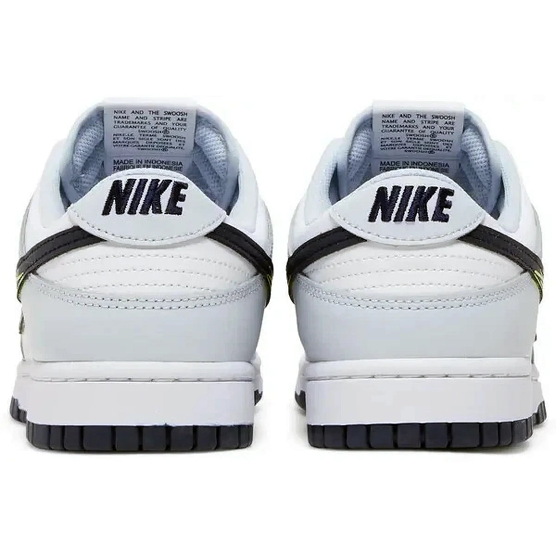 Nike Dunk Low 3D Swoosh – Rückansicht der weißen Sneaker mit schwarzem „NIKE“-Schriftzug auf der Ferse, mehrfarbigem 3D-Swoosh an der Seite und dunkelgrauer Außensohle auf weißem Hintergrund