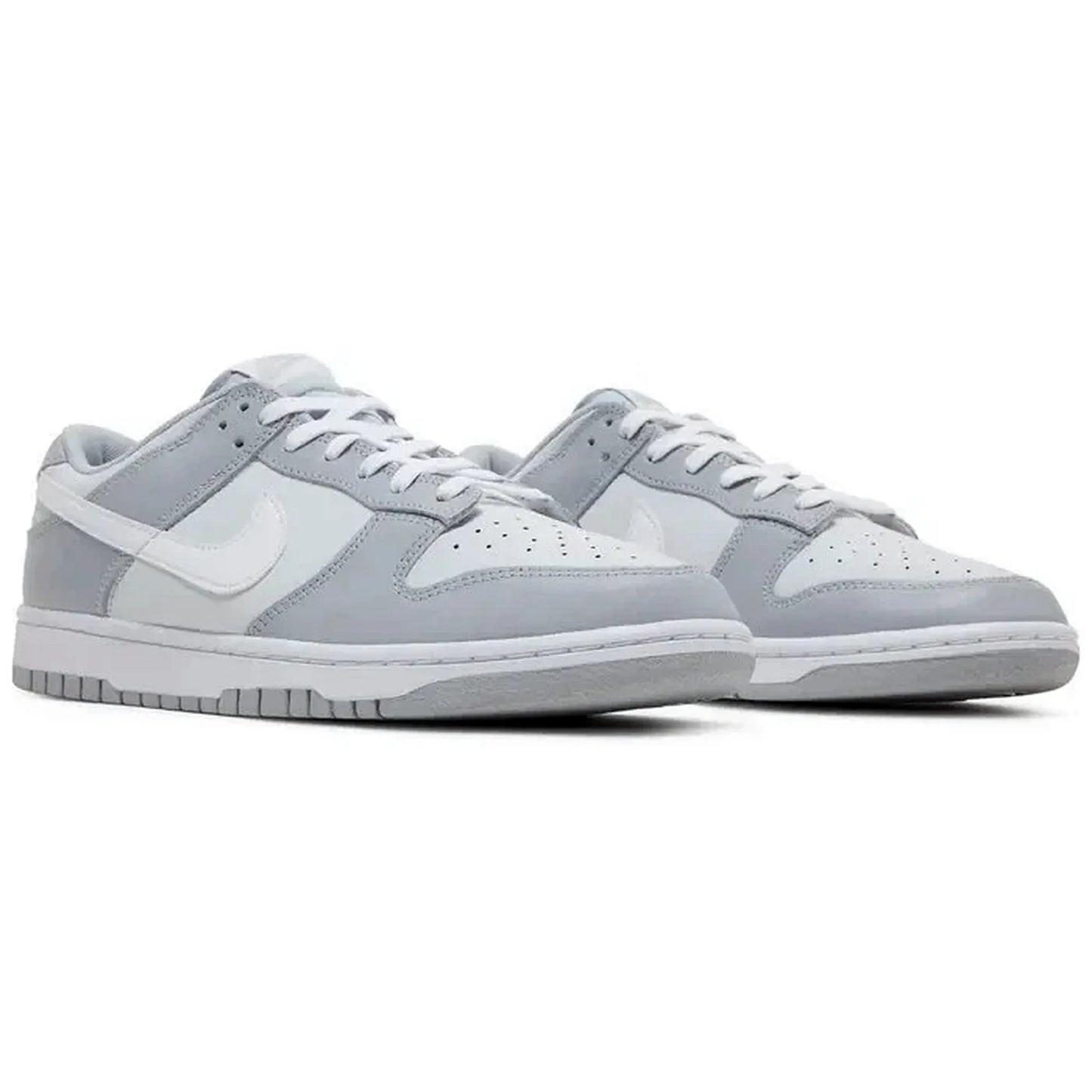 Nike Dunk Low Two Tone Grey – Paaraufnahme des grauen und weißen Sneakers aus Leder mit perforierter Toebox, fotografiert in schräger Frontansicht auf weißem Hintergrund.