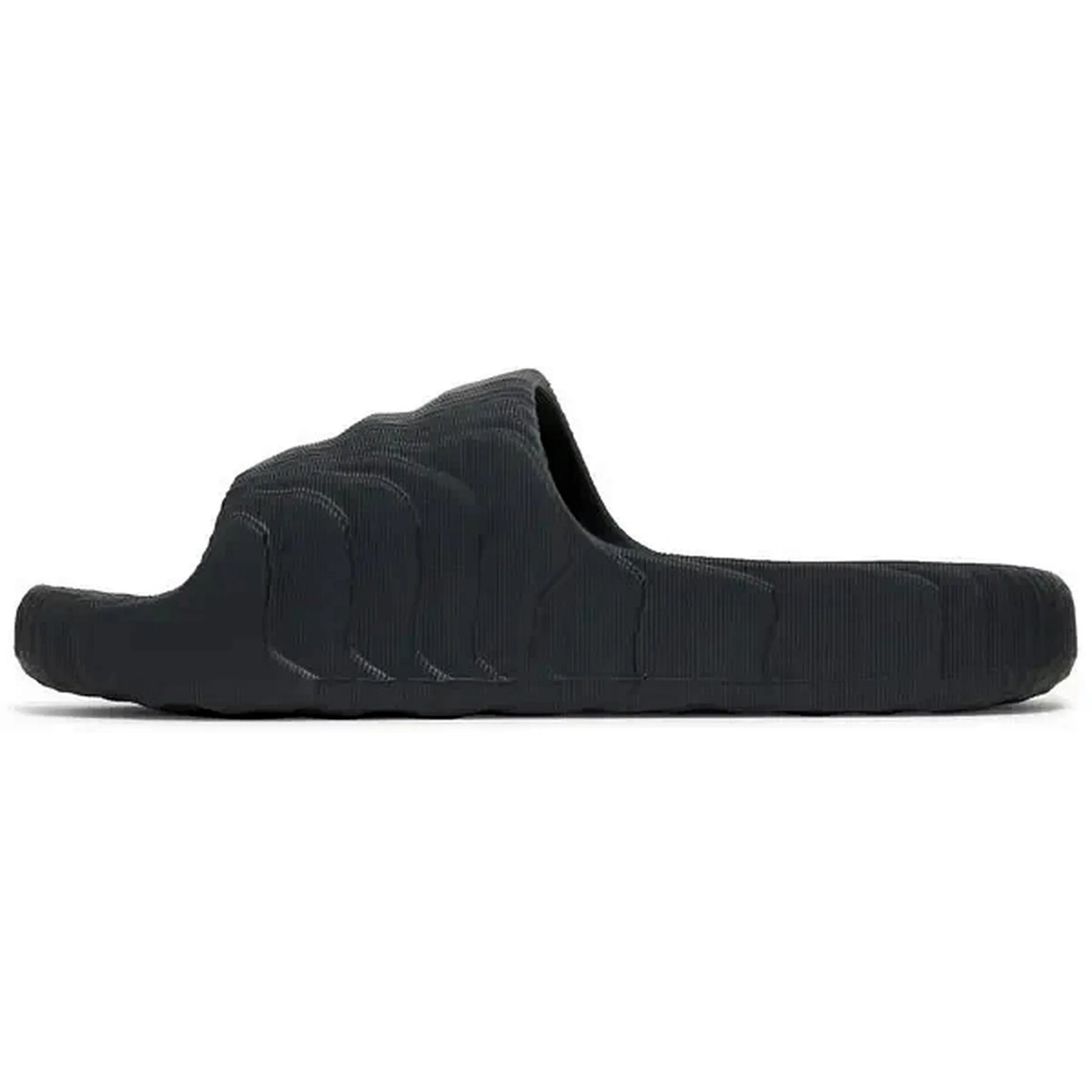 Adidas Adilette 22 Slides in Carbon-Schwarz, Seitenansicht der Sandale mit futuristischer, wellenförmiger Struktur und minimalistischem Design, auf weißem Hintergrund fotografiert.