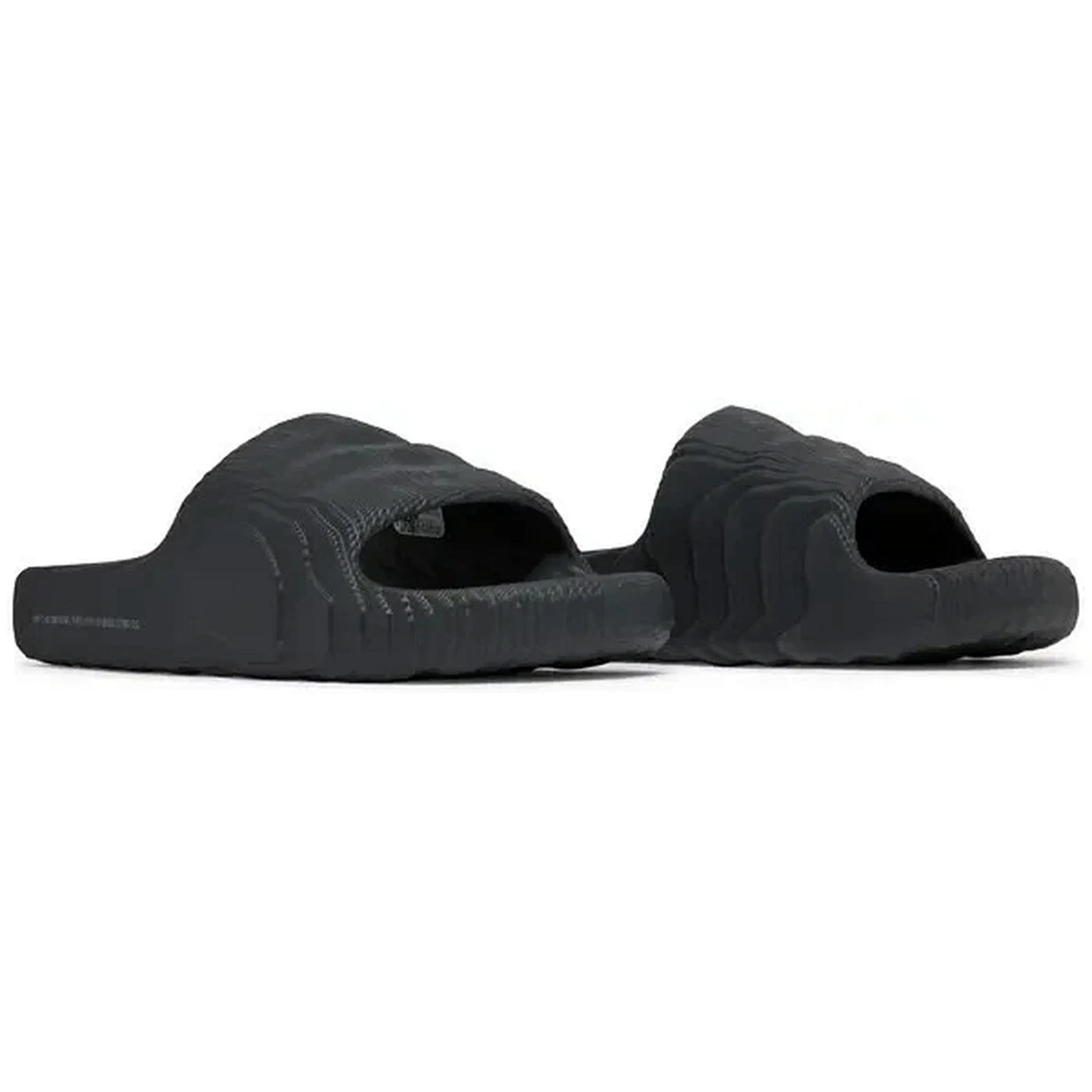 Adidas Adilette 22 Slides in Carbon-Schwarz, Paaransicht der Sandalen in schräger Perspektive mit strukturiertem, futuristischem Design, präsentiert auf weißem Hintergrund.