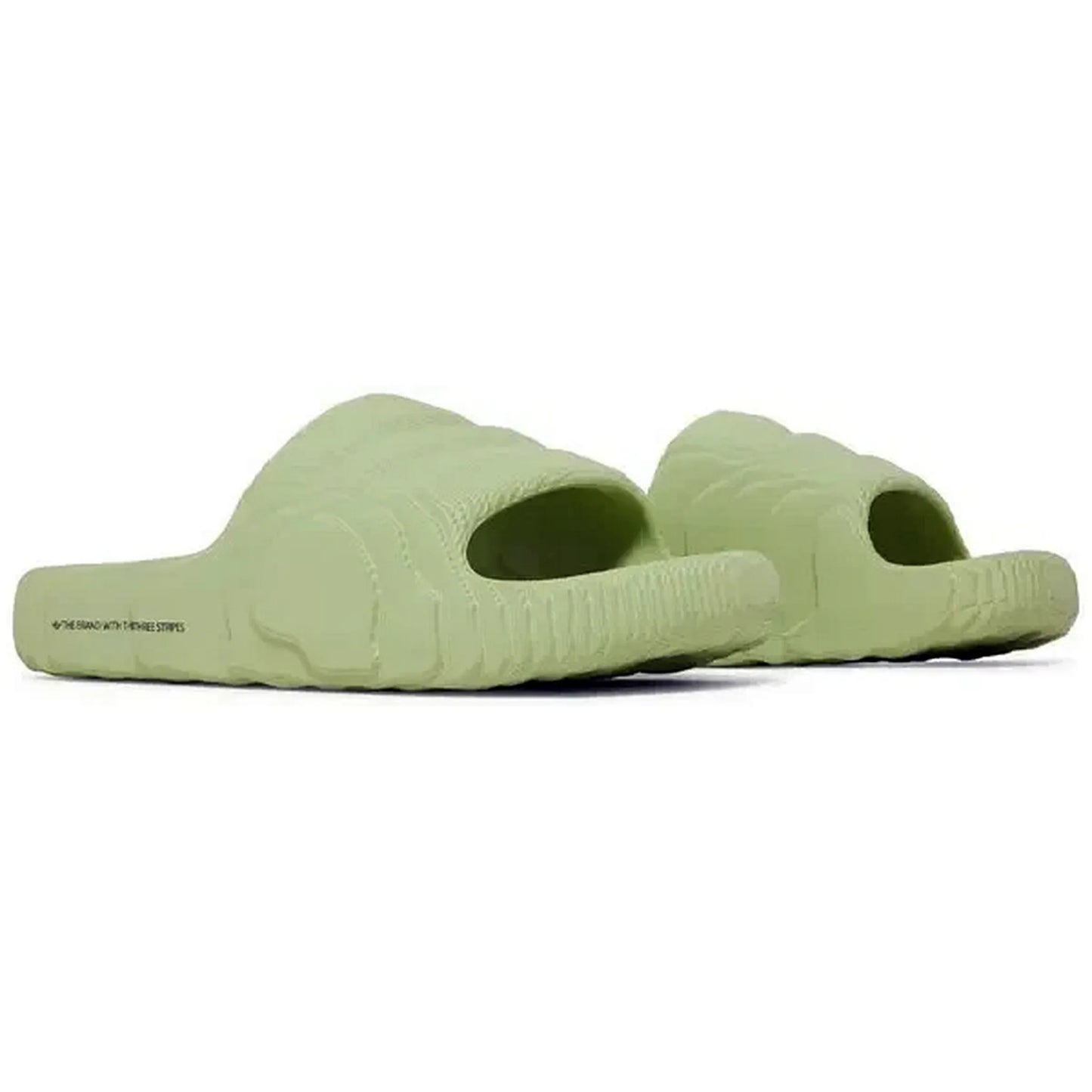 Adidas Adilette 22 Slides in Magic Lime, Paar hellgrüner Sandalen in seitlich-schrägem Winkel, mit futuristischem 3D-Design und wellenförmiger Struktur, präsentiert auf weißem Hintergrund.