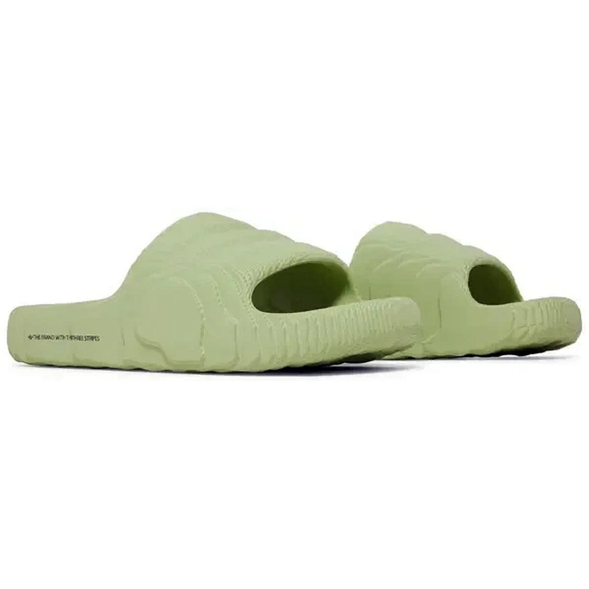Adidas Adilette 22 Slides in Magic Lime, Paar hellgrüner Sandalen in seitlich-schrägem Winkel, mit futuristischem 3D-Design und wellenförmiger Struktur, präsentiert auf weißem Hintergrund.