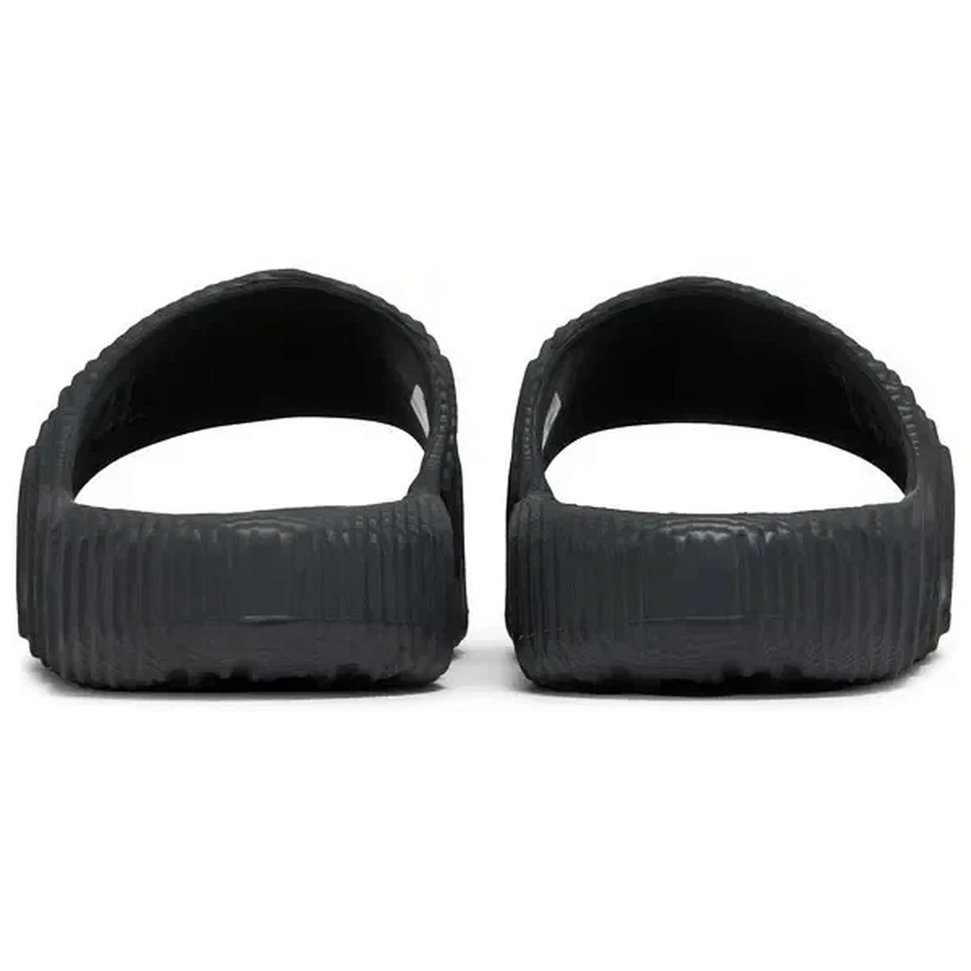 Adidas Adilette 22 Slides in Schwarz, Rückansicht der Sandalen mit strukturierter Oberfläche und offenem Fersenbereich, auf weißem Hintergrund fotografiert.